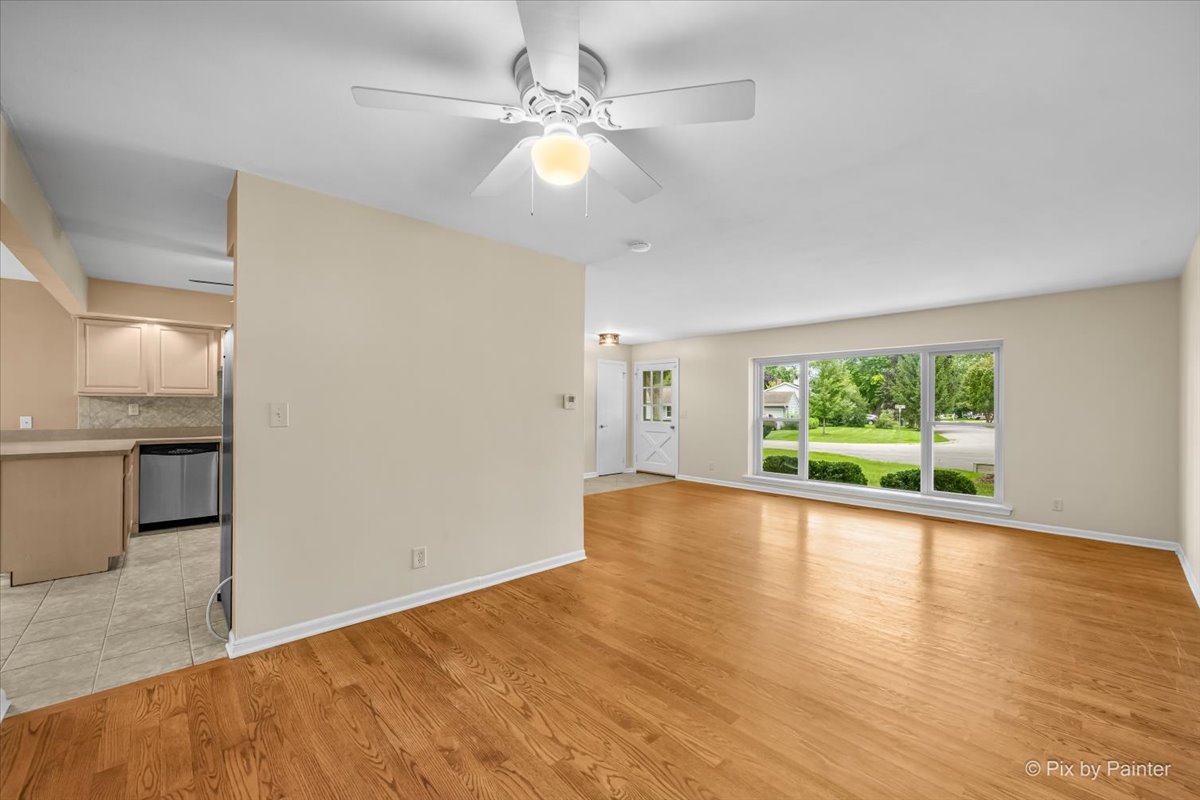 Living room with ceiling fan, opening through to the kitchen