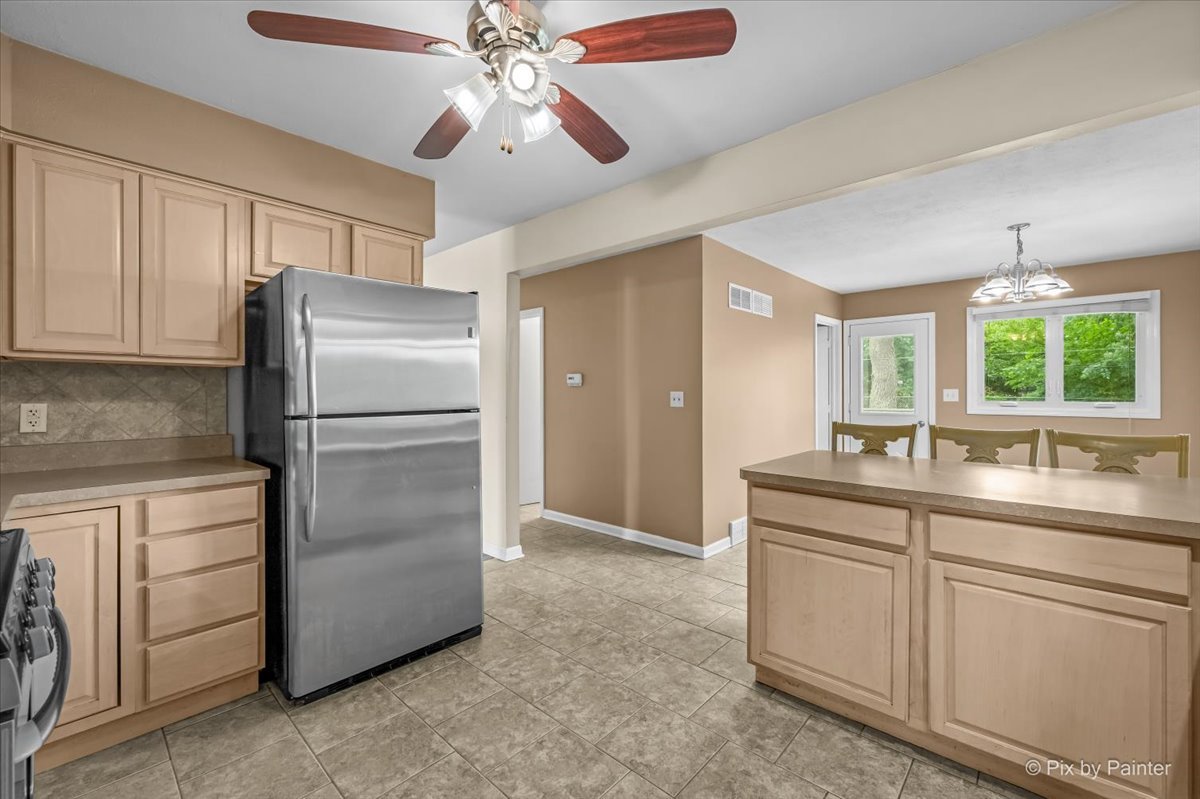 Kitchen with stainless refrigerator, looking through to the dining area