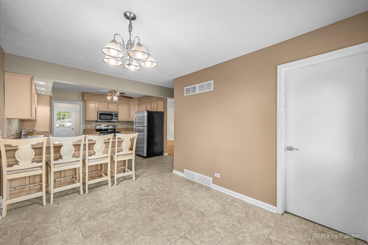 Breakfast bar seating with the kitchen and pantry door beyond