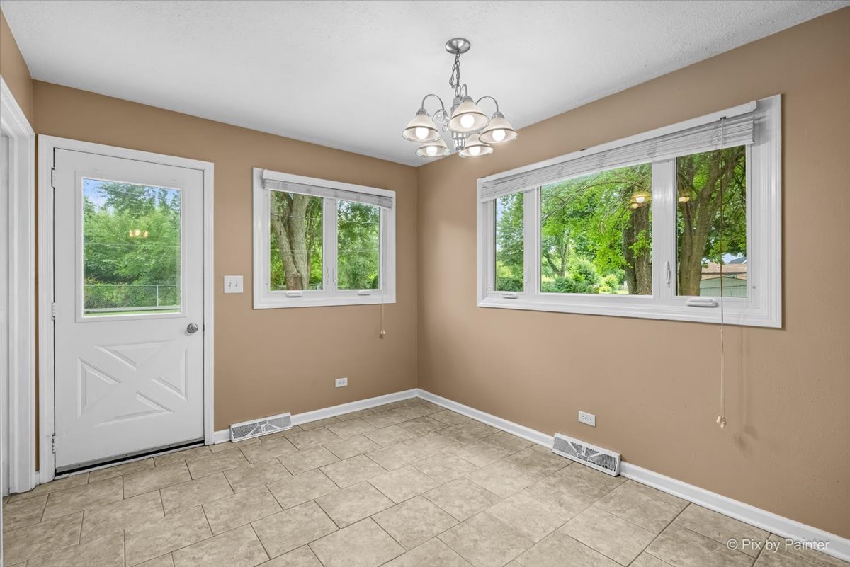 Breakfast nook with a chandelier, two windows, and a door to the back yard